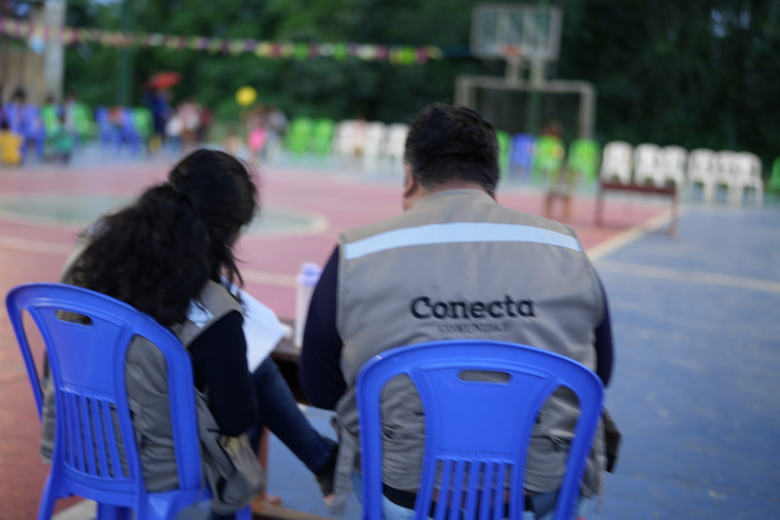 Integrantes del equipo de Conecta, con chalecos de la firma, trabajando de espaldas en Ticumpinía.